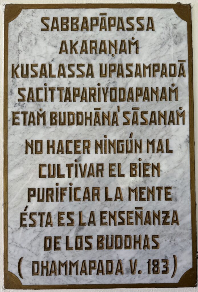 Placa de mármol a la entrada del Dhamma Vihāra con el verso 183 del Dhammapada.